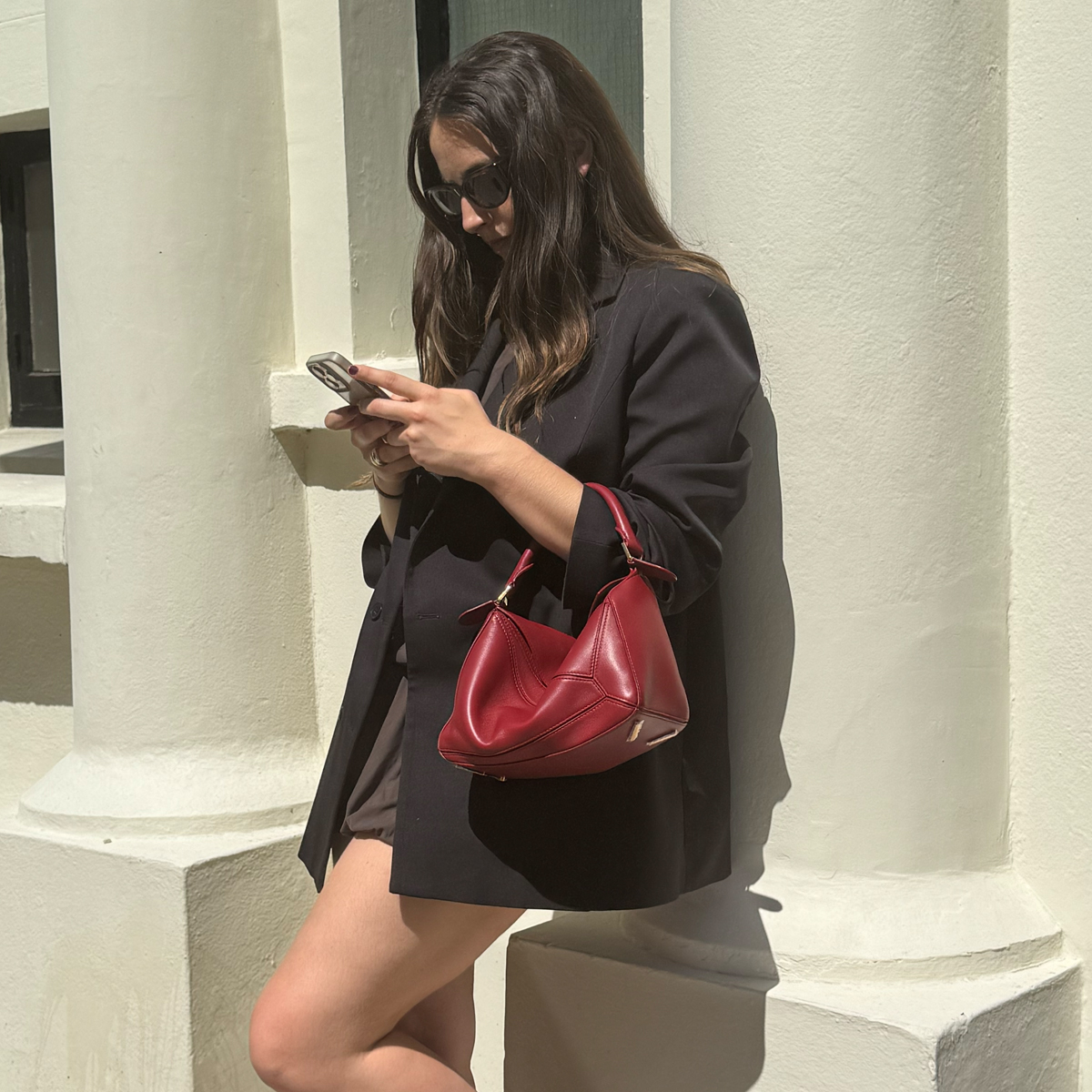SEO Writer Ava Gilchrist carries a red Loewe Puzzle bag 