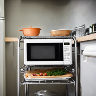 Microwave on a rolling cart in a small kitchen