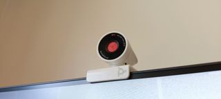 A white Poly Studio P5 webcam sitting on top of a monitor