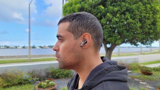The reviewer pictured wearing the Edifier NeoBuds Pro earbuds