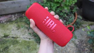 a hand holding the jbl flip 6 outdoor speaker