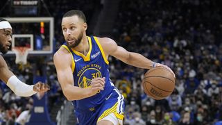 Stephen Curry #30 of the Golden State Warriors dribbling the ball drives towards the basket on Oshae Brissett #12 of the Indiana Pacers