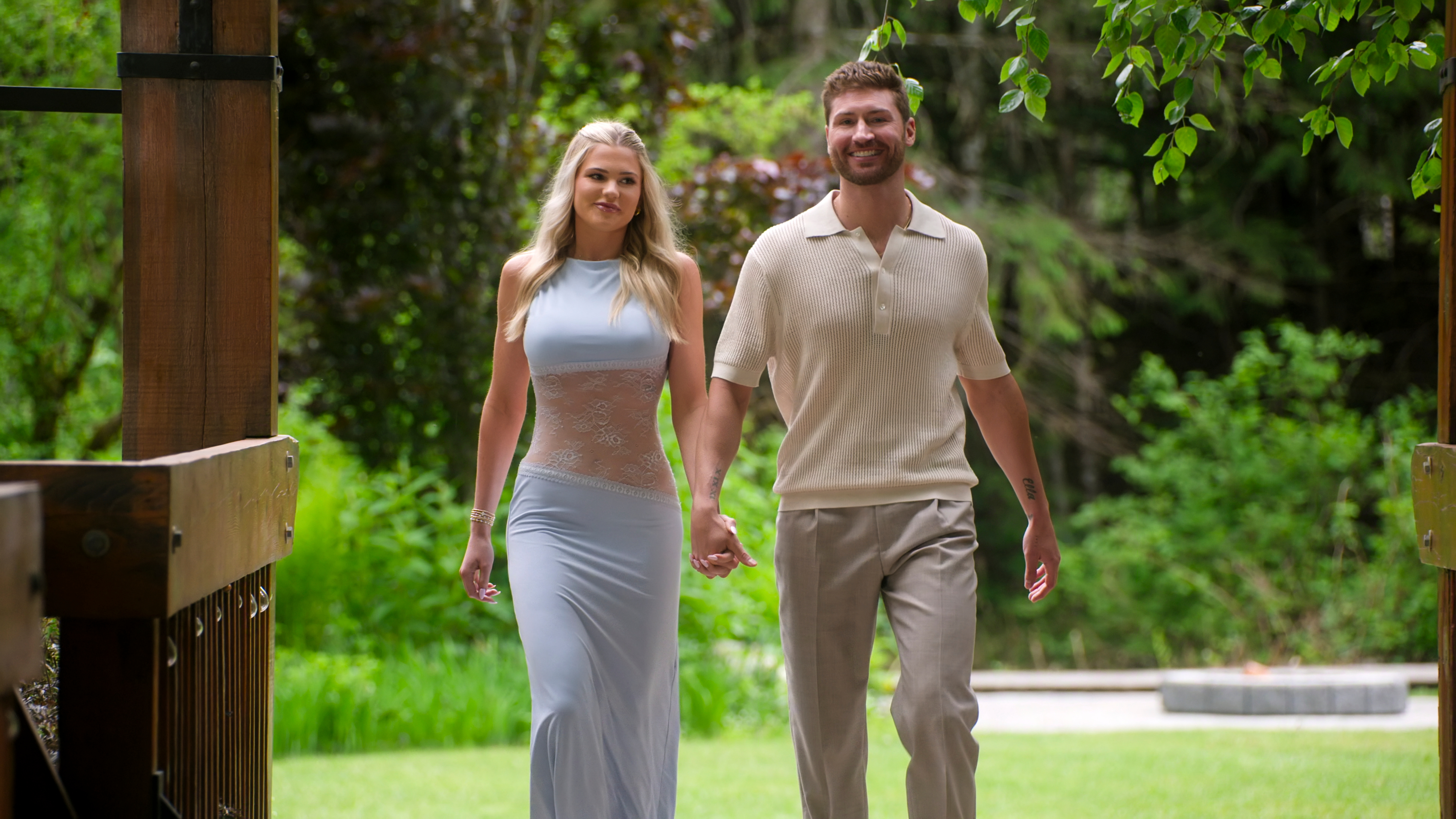 age of attraction couple libby and andrew walk through a field holding hands