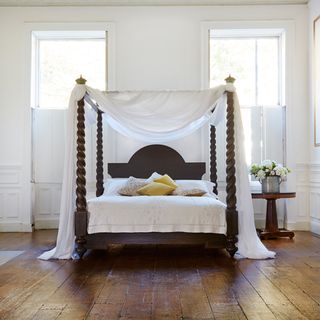 bedroom with white drapes four poster bed