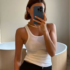 Woman in white tank top and black pants
