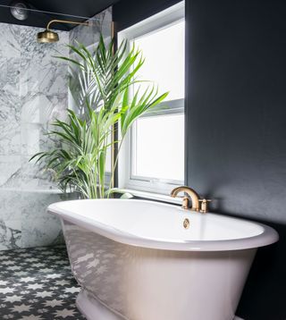 black bathroom with white marble tiled shower and monochrome geometric floor tiles