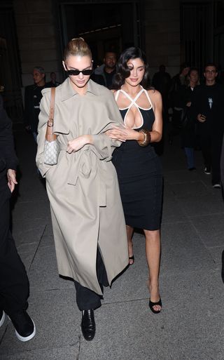 Kendall Jenner and Kylie Jenner at Paris Fashion Week where Kendall wears a trench and a gucci bag