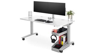 Uplift V2 standing desk review: An image showing the desk in white, and dressed with a double monitor and a small plant in a gold planter