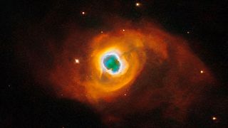 swirling red, orange and yellow clouds wrap around a green center as surrounding stars shine