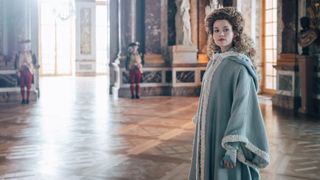 Marie Antoinette stands in a large room