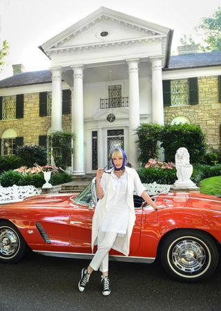 Joanna Lumley stands by a red Corvette at Gracelands Memphis Tennessee, Elvis's house
