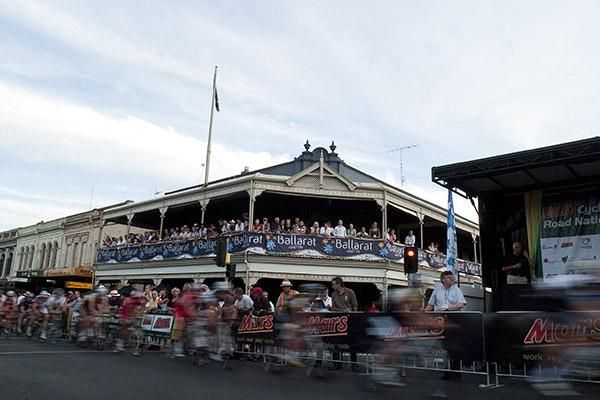 The field in the mens' elite race speed past one of the local hotels in Sturt Street Ballarat which was pumping with spectators on a hot night of racing.
