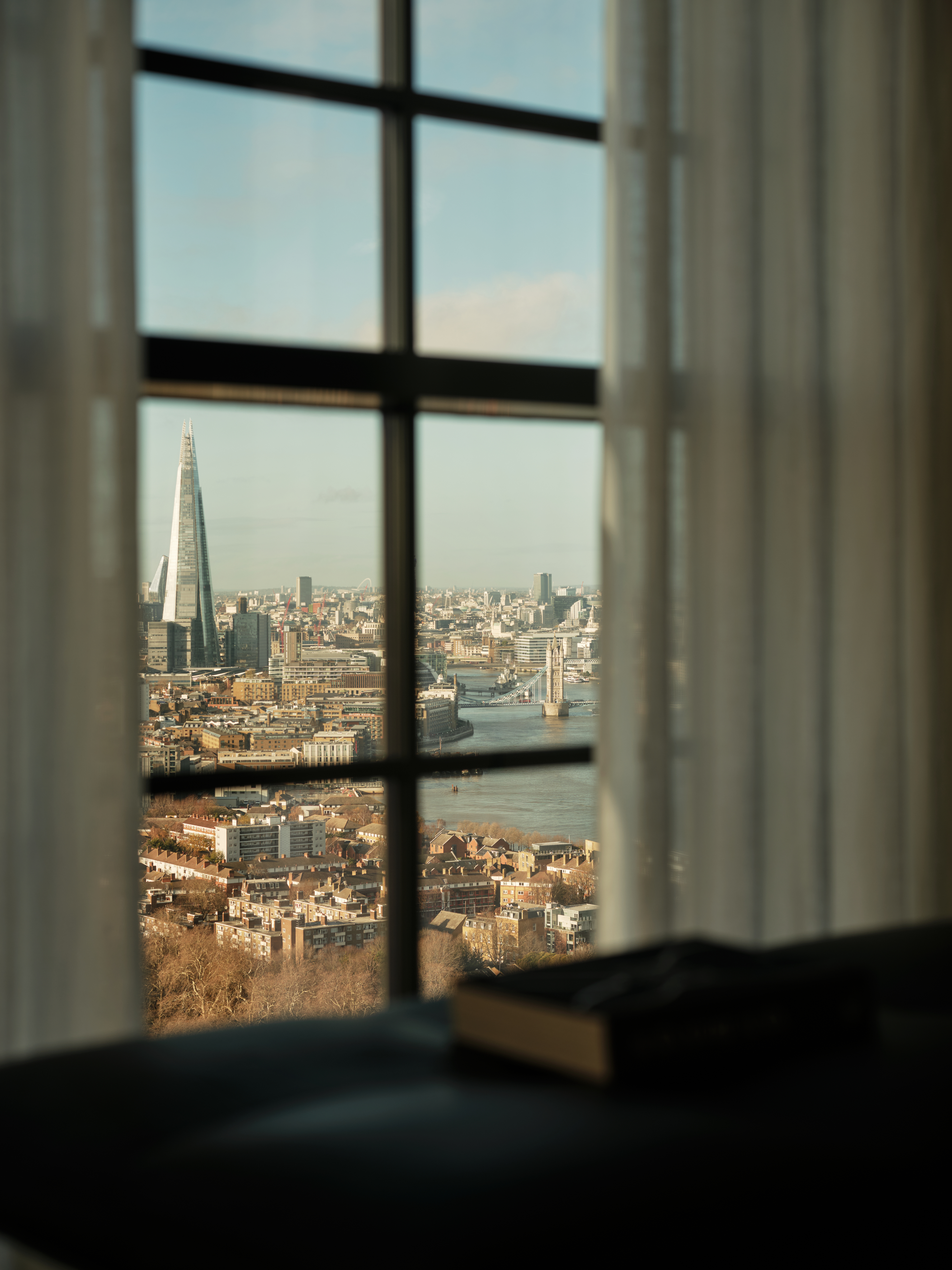 view of the Penthouse at The Founding by Conran and Partners, including timber based furniture and warm colours under moody lighting