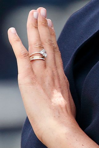a close up of meghan markle engagement ring as well as her gold wedding ring and her diamond eternity band