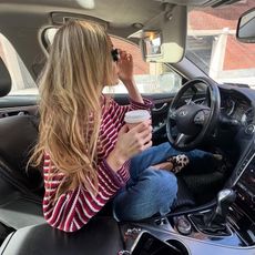 NYC style influencer Courtney Grow poses in a car wearing chic pieces from J.Crew like a striped sweater, jeans, and animal-print ballet flats
