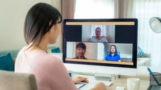 Woman looking at 3 faces on a computer monitor