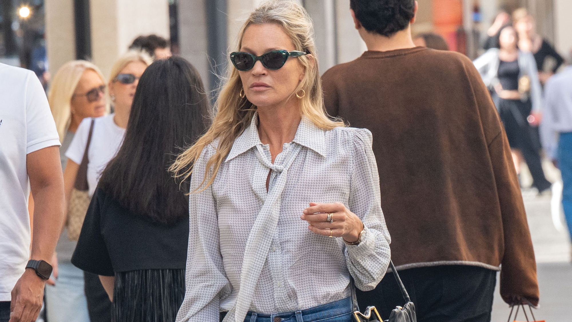 Kate moss wears a button-down shirt with black sunglasses.