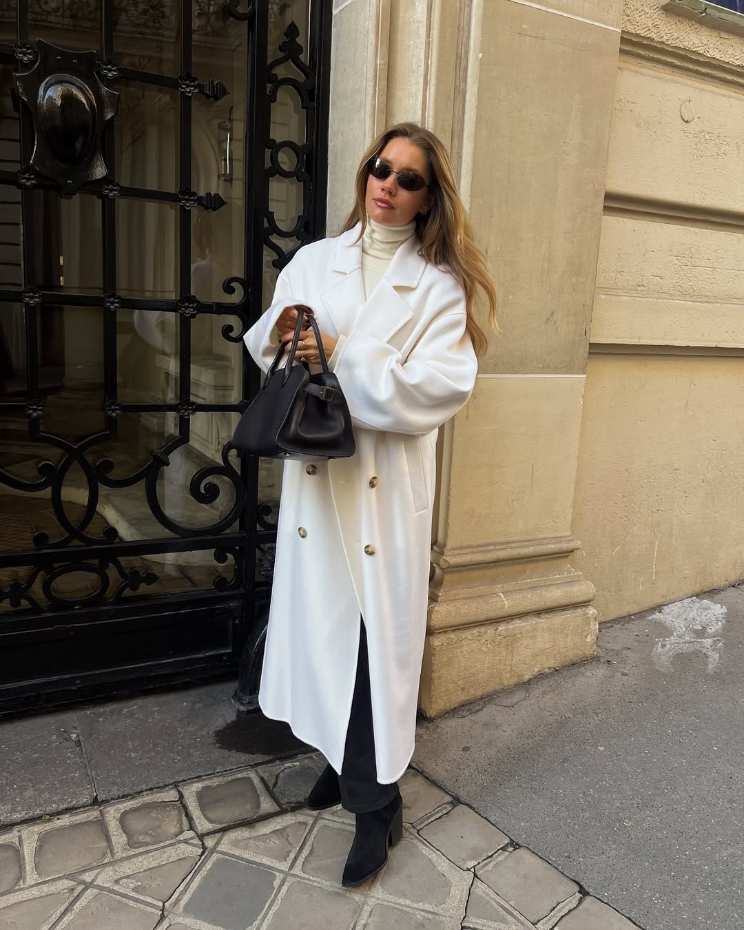 French woman wearing Western boots with white long coat.