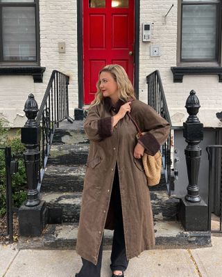 Woman wears brown long barn coat