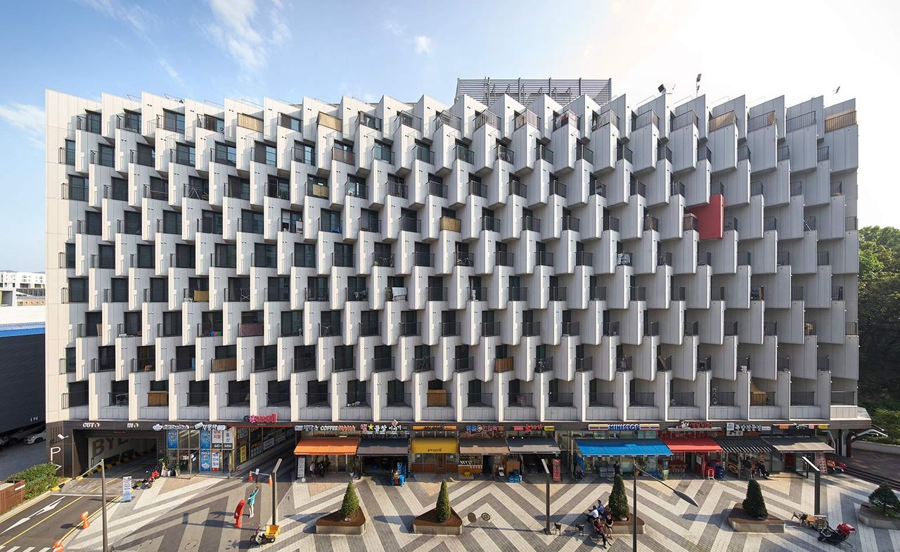 Gangnam Bogeumjari District Officetel in Seoul, a large concrete building with shops on the ground floor with apartment balconies over several upper floors