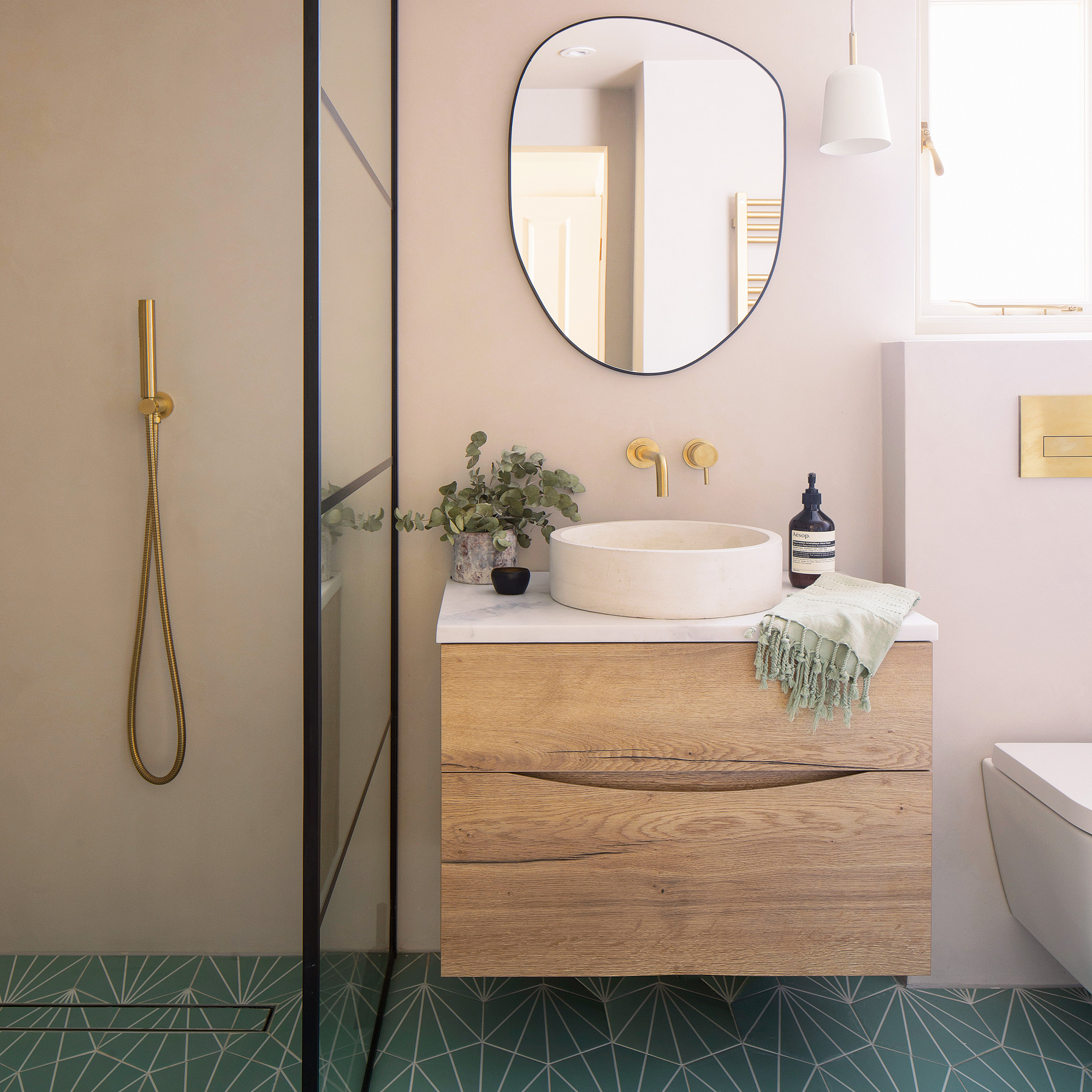 bathroom basin and shower with green tiled floor