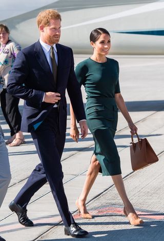 Prince Harry and Meghan Markle who's carrying a Strathberry's classic tote in Tan Bridle Leather