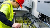 A technician checks cryptomining immersion cooling