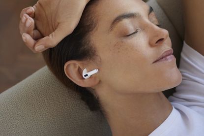 Woman listening to airpods in bed