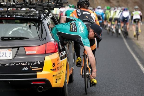 Optum Cycling's mechanic Eric Jellum helps Jesse Anthony with an adjustment.