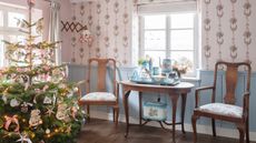 christmas tree decorated in a vintage style with two antiques armchairs to the left