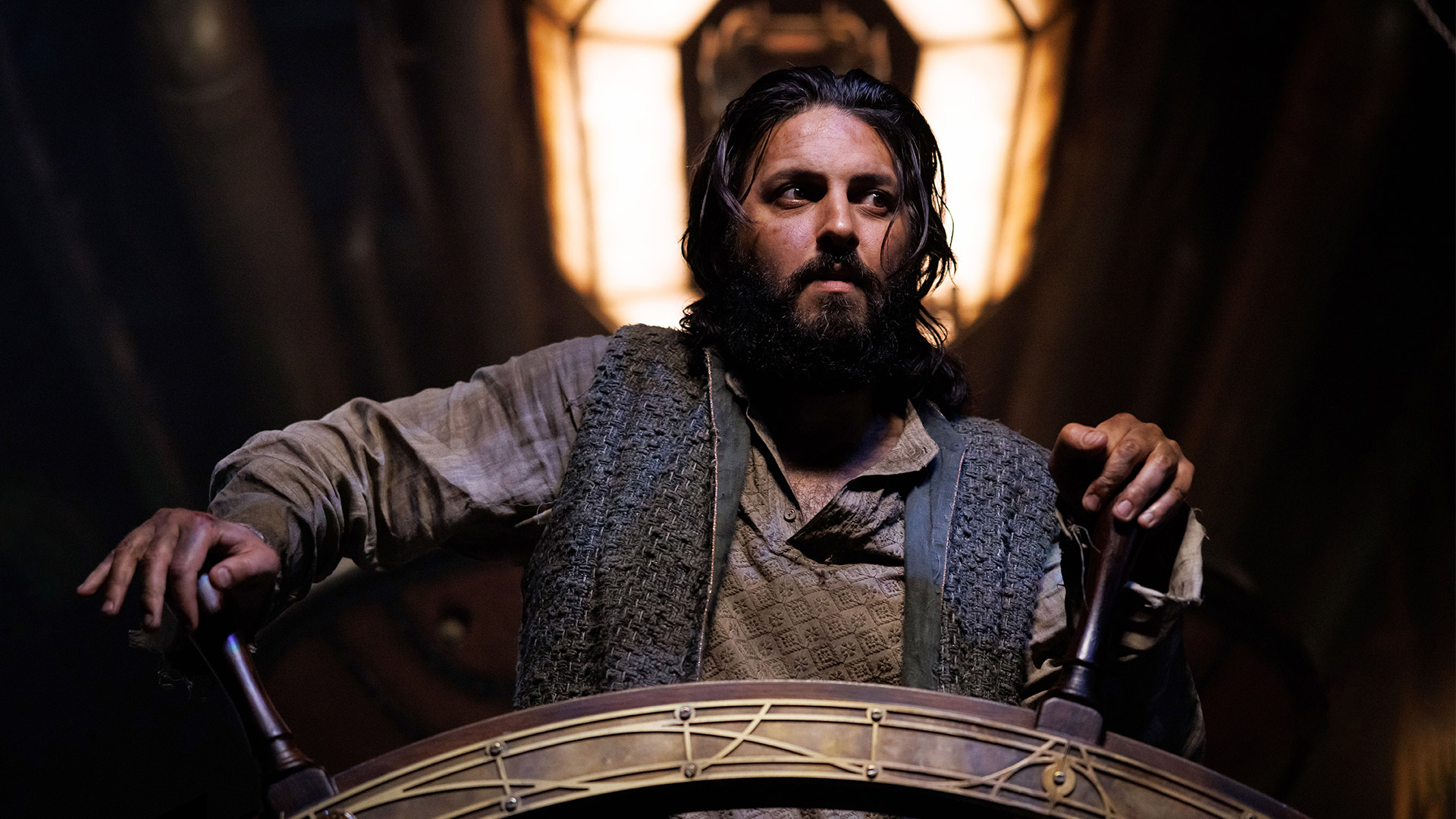 a bearded man at the steering wheel of a steampunk submarine