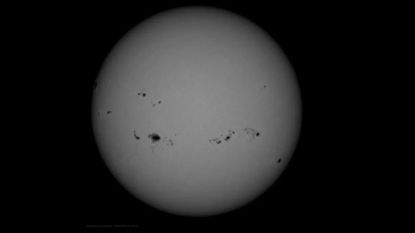 A gray orb with roughly a dozen small black spots on it