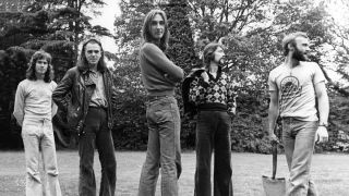 The peter Gabriel-era lineup of Genesis standing amongst trees