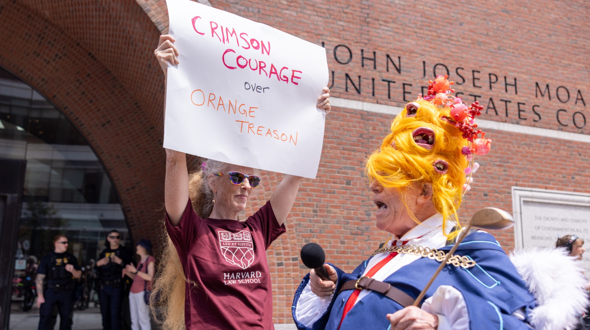 BOSTON, MASSACHUSETTS - JULY 21: A person dressed as Donald Trump interacts with a group of protestors outside of the John Joseph Moakley United States Courthouse on July 21, 2025 in Boston, Massachusetts. Lawyers for Harvard University argued in federal court on Monday that the federal government's freeze of more than $2 billion in grants and contracts is illegal and should be reversed. (Photo by Scott Eisen/Getty Images)