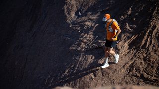 A hiker wearing the Scott Ultra Explore trail running shoe on loose terrain