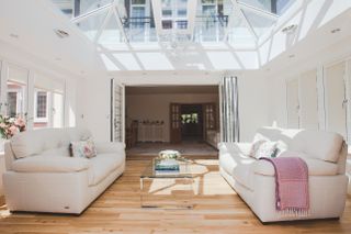 while living room in a sunroom with large roof lantern and bifolding doors