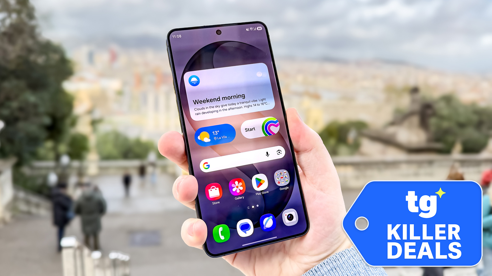 Hand holding Samsung Galaxy S26 Plus with killer deals badge overlaid