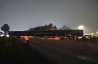 At 156 feet long (47 meters), SpaceX's Falcon 9 first stage briefly blocked traffic in one direction on NASA Road 1 as it was carefully backed into Space Center Houston's parking lot.