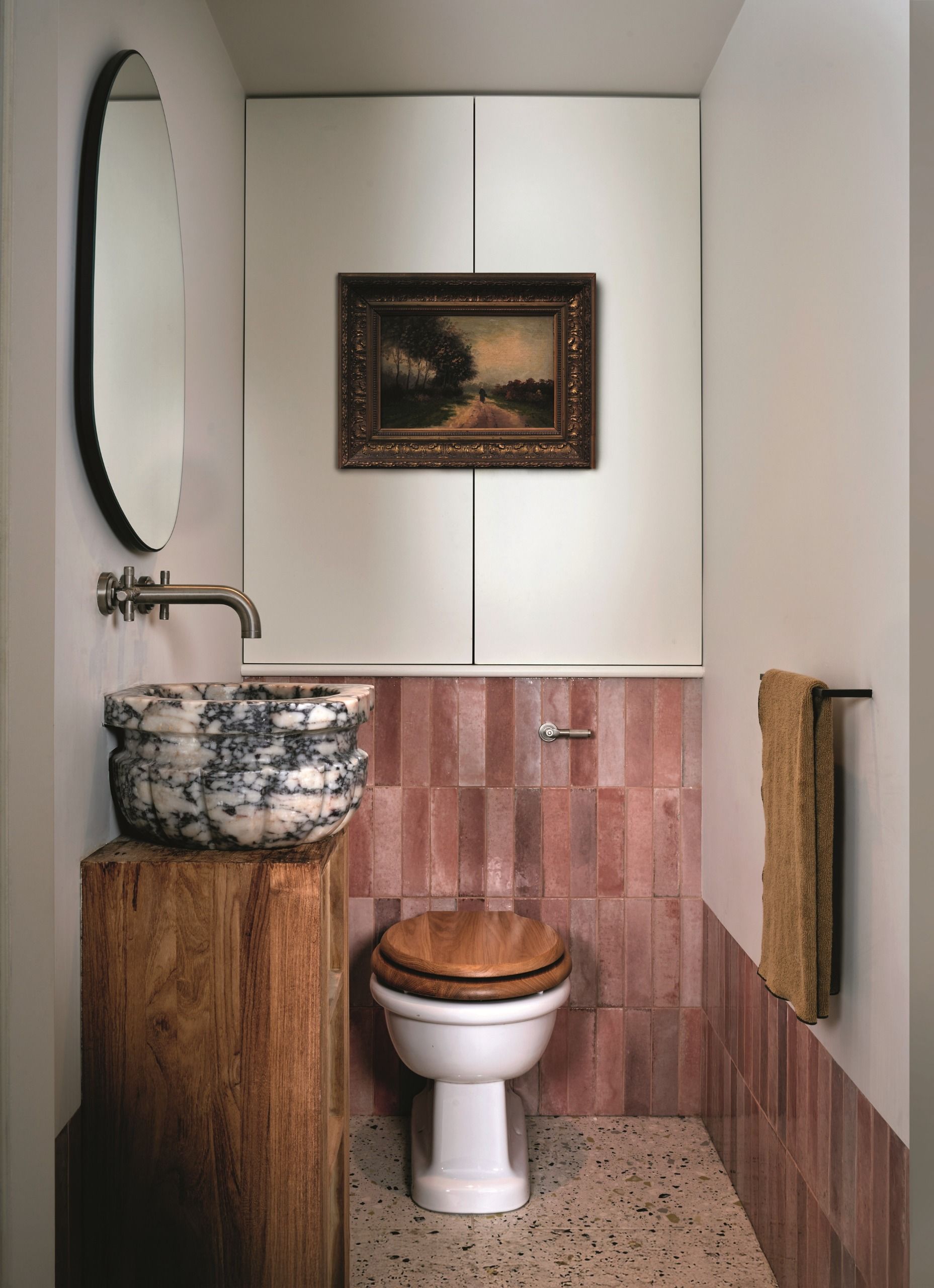 a small bathroom with pink tiles and a marble sink