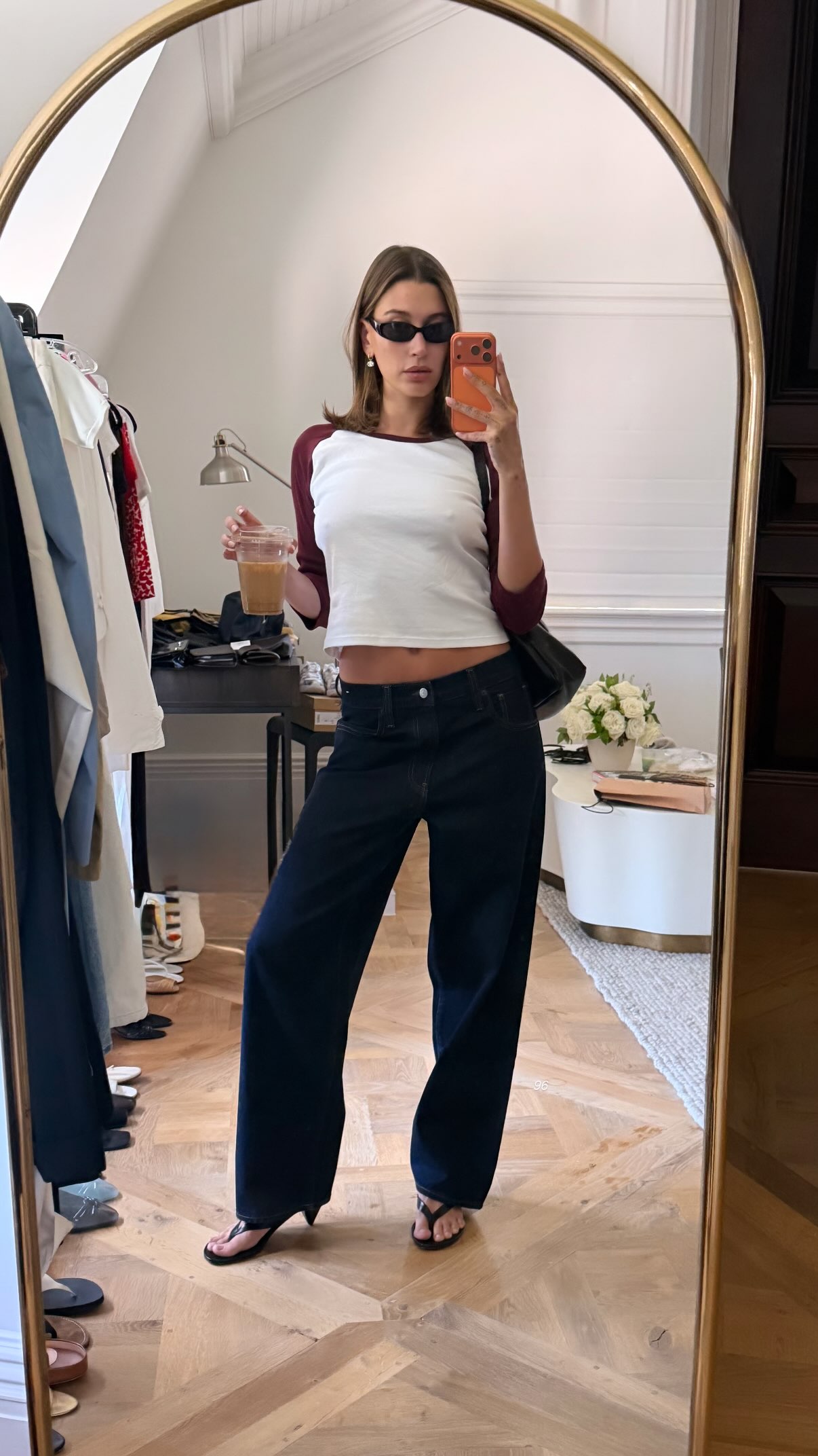 Hailey Bieber wore low-rise, dark-wash jeans with the heeled flip-fllops and baseball tee trends