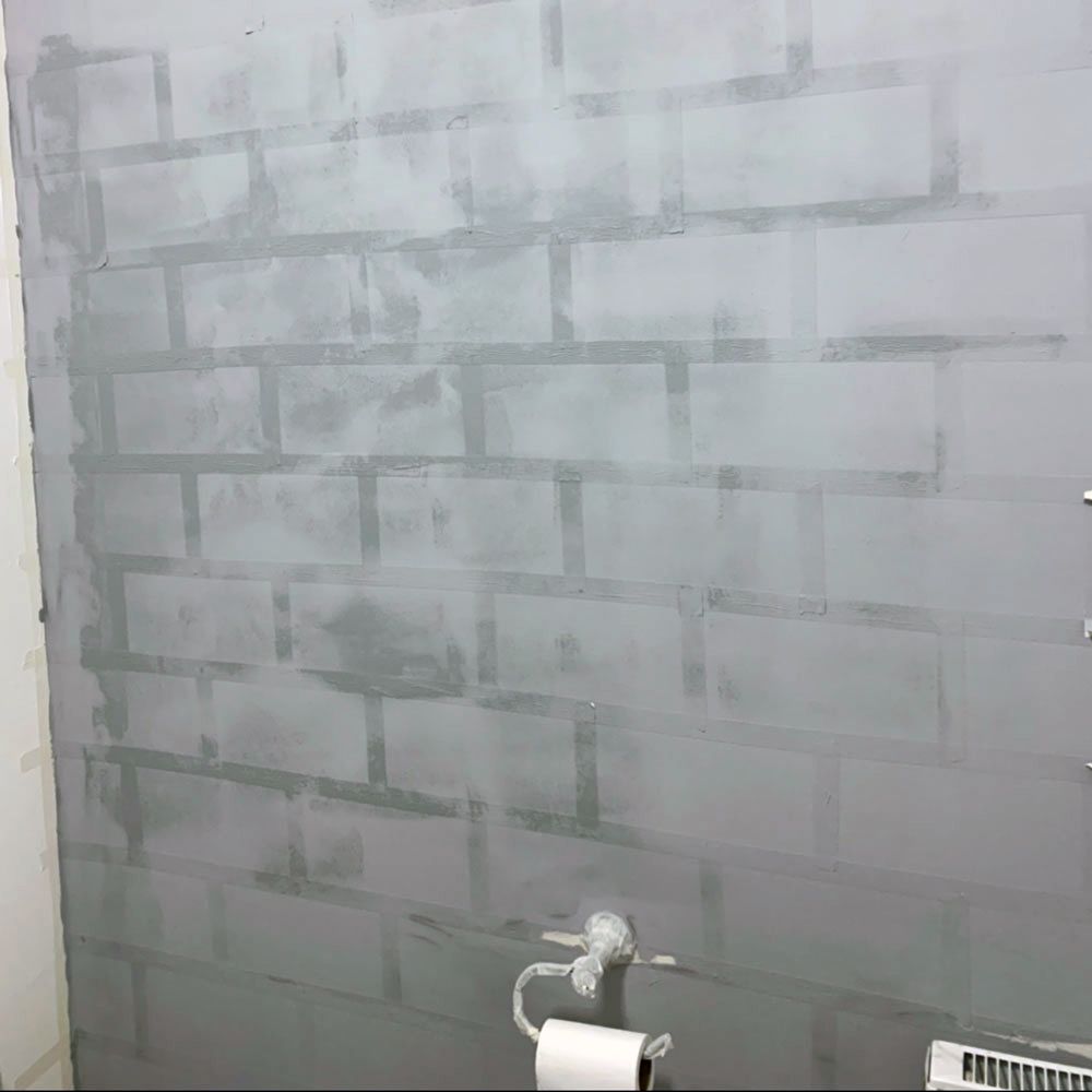 Homeowner paints brick feature wall in her bathroom using masking