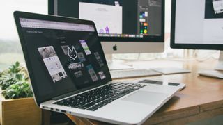MacBook on desk open on web design app