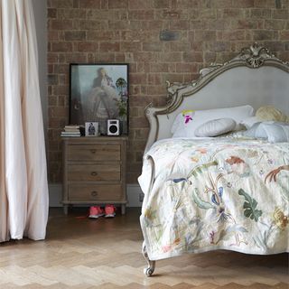 Floral linen with vintage headboard and wood side table