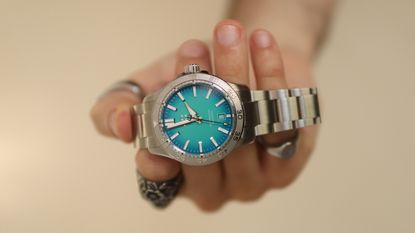 The Christopher Ward C60 Atoll 300 in Blue held in a hand