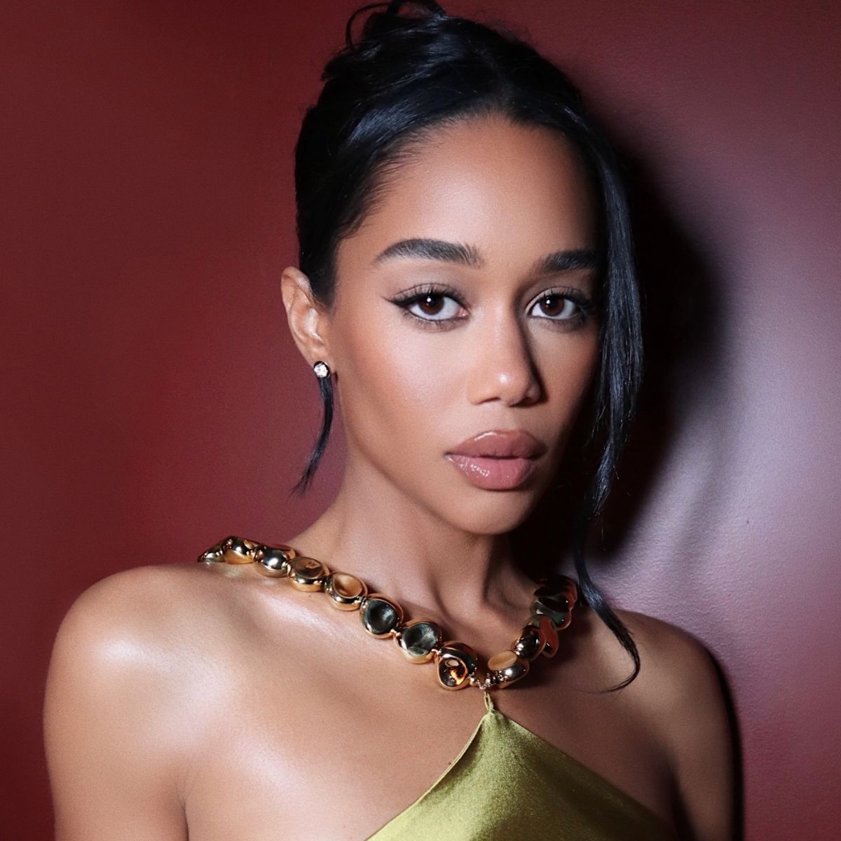 A headshot of Laura Harrier wearing a green dress