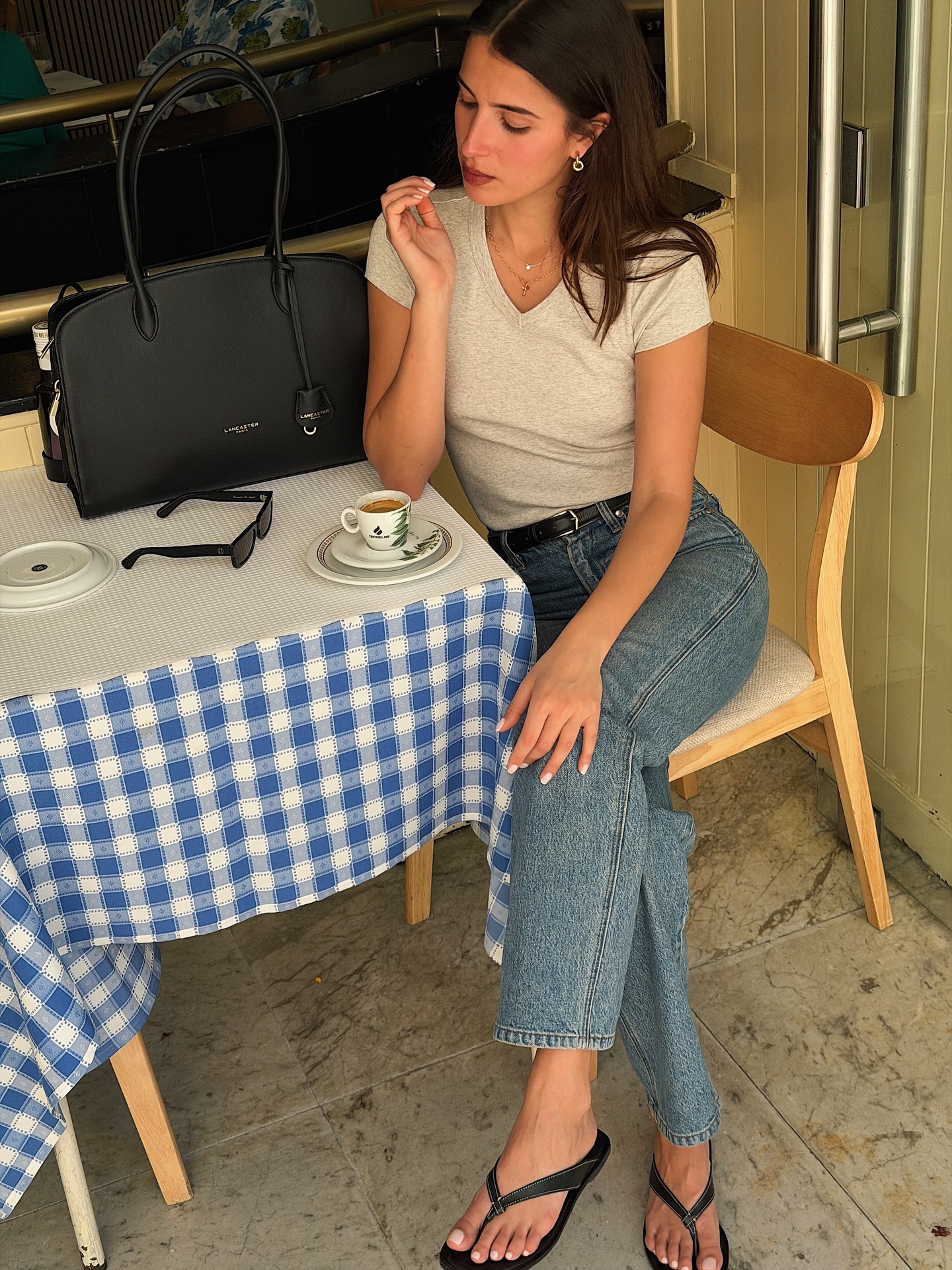 Woman in jeans, a tee, and flip flops.