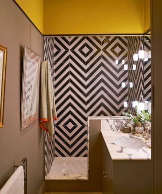 yellow and taupe shower room with black and white geometric tiles