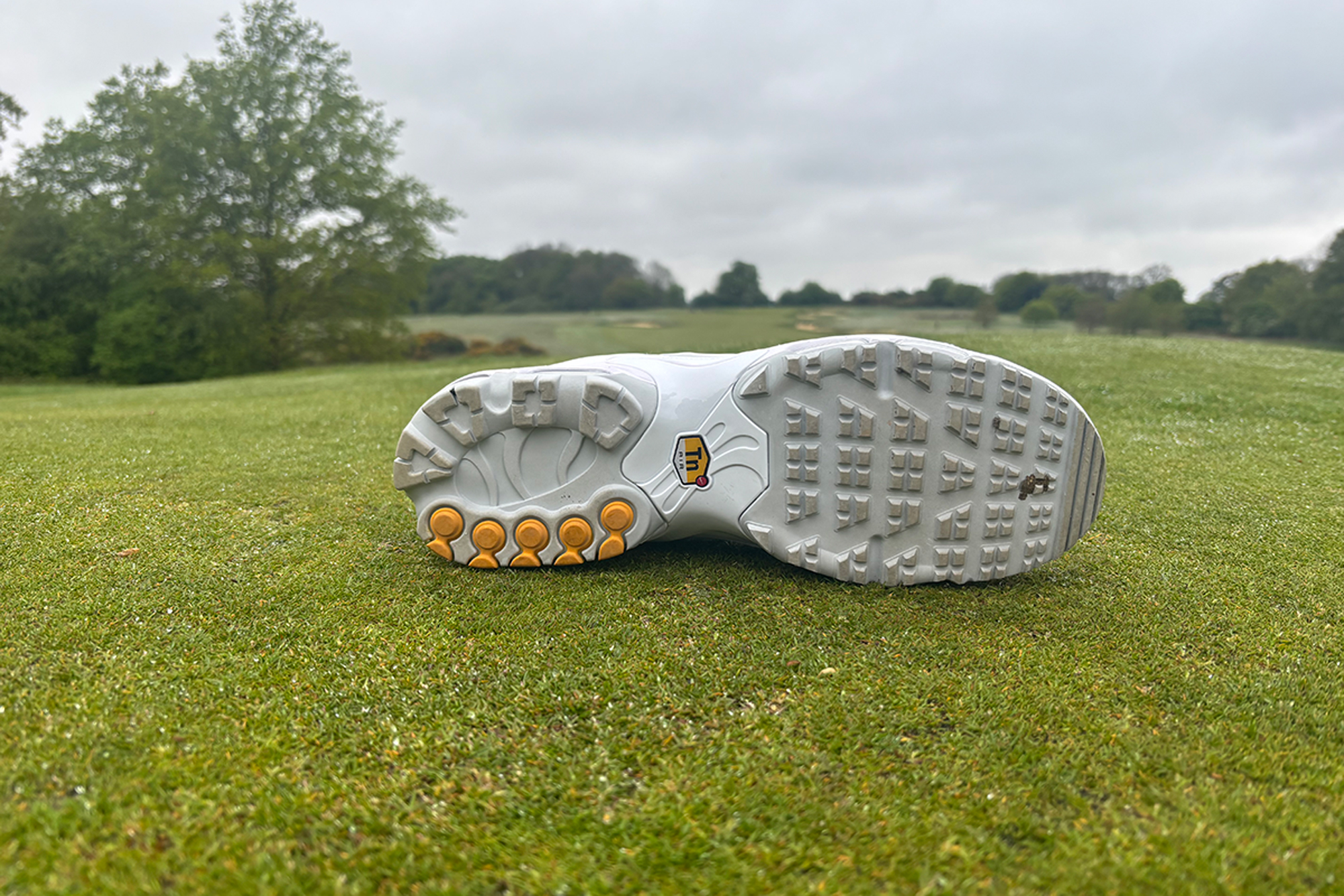 Nike Air Max Plus G Golf Shoe on its side showing the sole on the putting green at the Caversham Golf Club