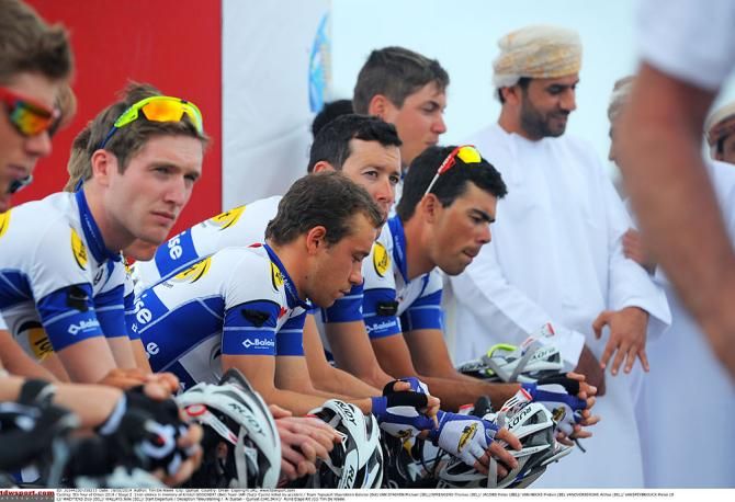 Riders pause during a minute of silence in memory of Kristof Goddaert
