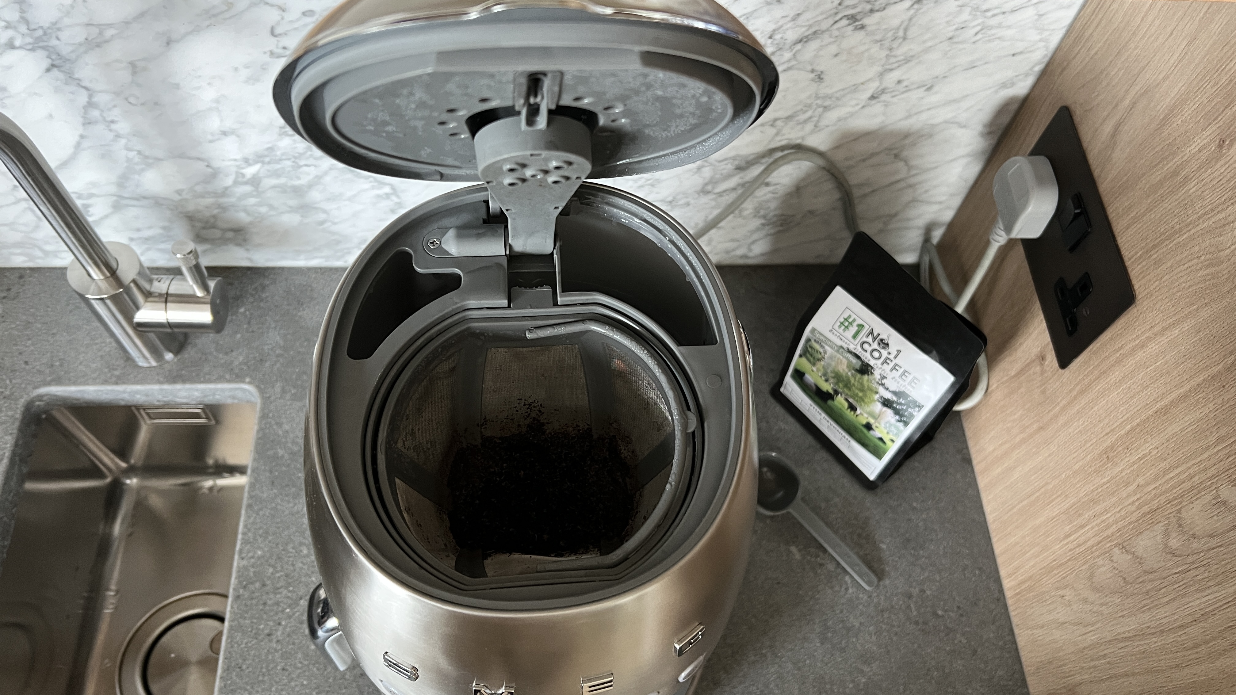 Smeg coffee machine open lid showing grounds basket